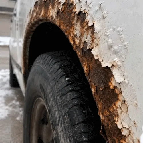 Rust damage around the wheel arch of an older vehicle
