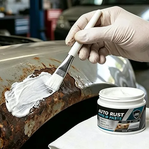 Brush applying rust repair paste to a rusted automotive panel